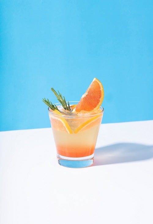 Grapefruit garnish on glass containing grapefruit thyme vodka cocktail